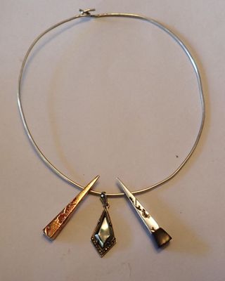 un collier en argent orné de trois breloques différentes