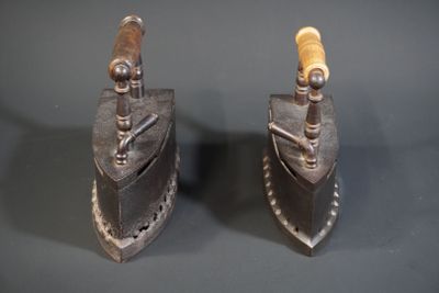 pair of antique iron and wood clamps on a gray surface