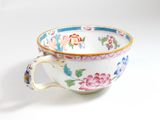 a cup with a handle that has a flower design on it