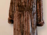 un manteau de fourrure posé sur un mannequin devant une lampe
