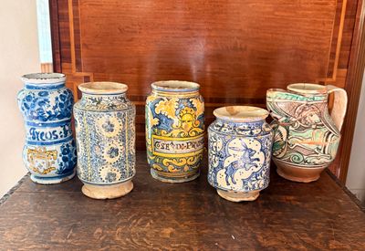Plusieurs vases sont alignés sur une table devant un mur