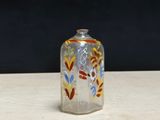 a glass bottle with a design on it sitting on a table