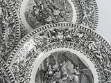 three black and white plates with pictures of people and animals on them