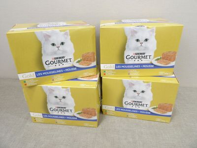 quatre boîtes de nourriture pour chat haut de gamme posées sur une table