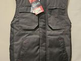 a black vest with a tag on it hanging on a wall
