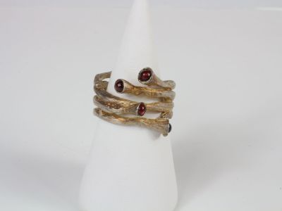 two gold rings with garnets and garnets on a white napkin