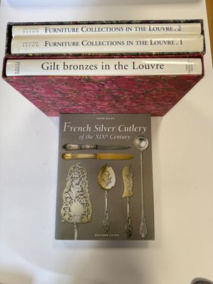 beaucoup de livres posés sur une table où se trouvent des couverts