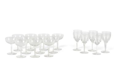 Plusieurs verres à vin transparents sont alignés sur une surface blanche