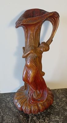 une statue représentant une femme tenant un vase posé sur une table