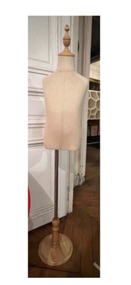 un gros plan sur un mannequin posé sur un socle dans une pièce