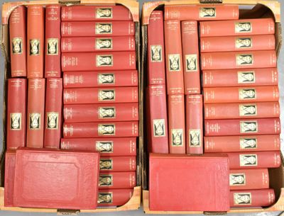 de nombreux livres rouges dans un coffret en bois posé sur une table