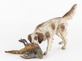 une figurine représentant un chien tenant un faisan dans la gueule