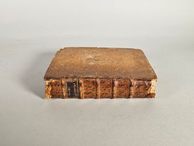 un vieux livre posé sur une table à fond blanc