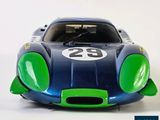 a blue and green toy car on a white surface