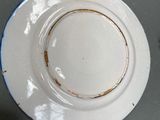 a white plate with a blue edge on a table