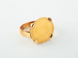 a close up of a gold coin ring on a white surface