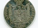 une vieille pièce d'argent sur laquelle figurent des armoiries surmontées d'une couronne