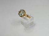 a close up of a gold ring with a blue topaz stone