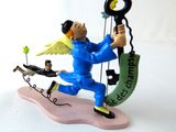 a figurine of an angel holding a key and a man on a swing
