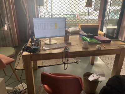 un bureau sur lequel se trouve un ordinateur, avec une chaise devant
