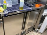 un plan de travail en acier inoxydable dans une cuisine au sol carrelé de bleu