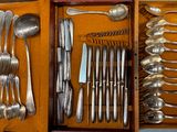 de nombreuses cuillères et cuillères-couteaux dans une boîte en bois