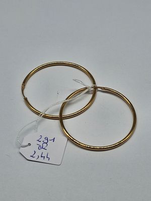 two pairs of gold hoop earrings with price tag on white surface