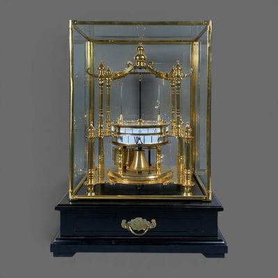 a clock that is in a glass case on a table