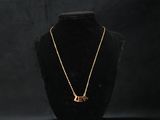 a gold necklace on a mannequin with a black background
