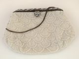 sac à main beige orné de perles sur fond blanc, avec une bandoulière en cuir marron