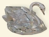 crystal swan figurine on a white surface with a white background