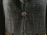a close up of a jacket with a rose brooch on it