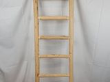 une échelle en bois appuyée contre un fond blanc