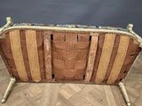 a wooden bench with a woven seat on top of it