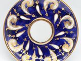 an image of a blue and gold plate on a white surface