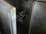 a metal sink in a kitchen with a trash can in it