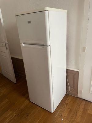 un réfrigérateur blanc dans le coin d'une pièce