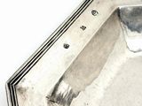 a silver tray with a silver handle on a white surface