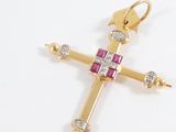 a close up of a gold cross with a pink and white cross on it