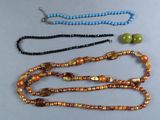 trois colliers de couleurs et de tailles différentes, ornés de perles