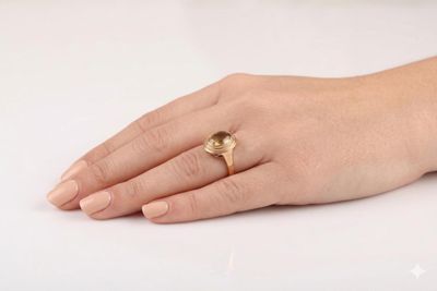 la main d'une femme à laquelle est passée une bague en or