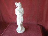 a statue of a woman holding a bird on a table