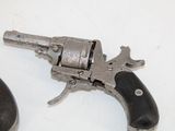 a small gun that is on the table next to a mouse