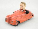 une petite voiture rouge avec un petit garçon à l'intérieur