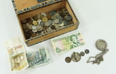 a wooden box filled with money and coins on a white surface