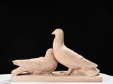 pair of white doves on a white pedestal against a black background