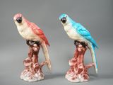 deux figurines représentant des perroquets perchés sur une branche d'arbre