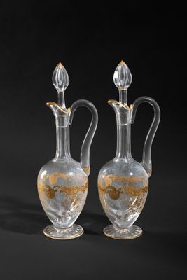 two clear glass vases sitting next to each other on a black surface