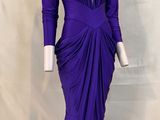 the dress is purple and has a deep v neck and long sleeves
