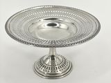 une assiette en argent posée sur un socle, sur fond blanc